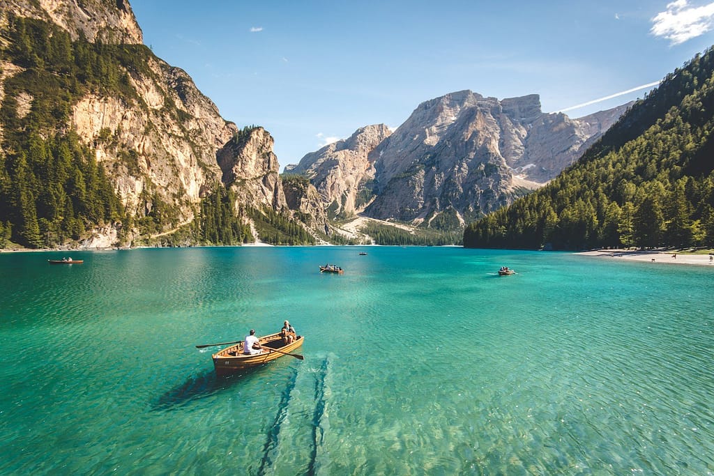 three brown wooden boat on blue lake water taken at daytime, international holidays