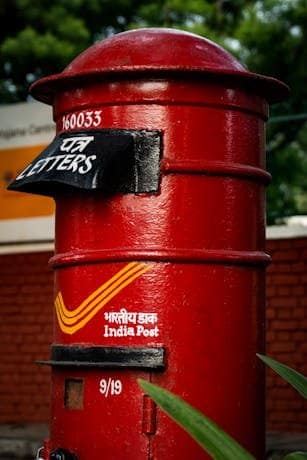 Close-up of a red India Post letterbox with vibrant colors in Chandigarh, India.