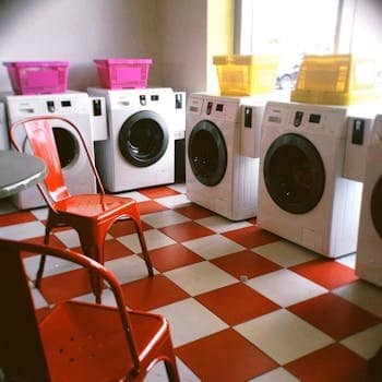 Bright laundry room with red checkered floor and colorful baskets, offering a modern look. maintain automatic washing machine.