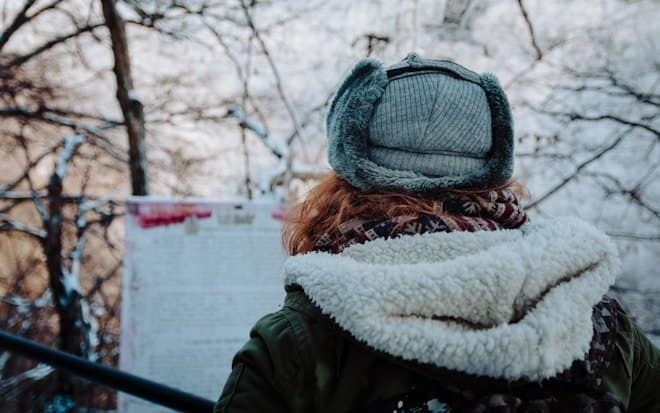 person wearing white and green jacket standing outdoor.