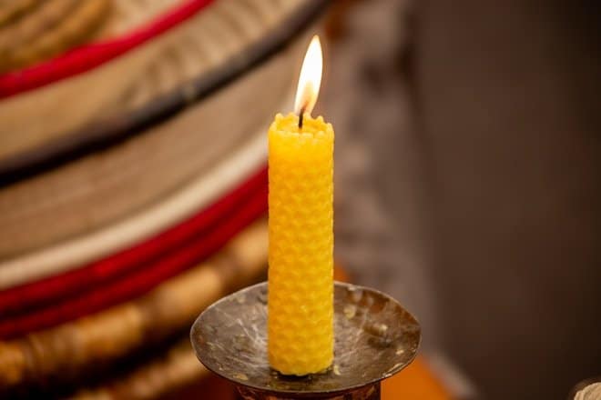 A yellow candle sitting on top of a metal container. Diwali home décor