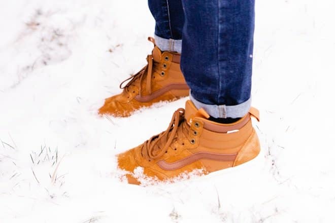 man steeping on snow. winter boots waterproof