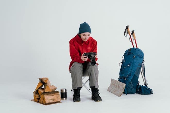 Woman in winter gear with backpack and map preparing for a hiking adventure.
